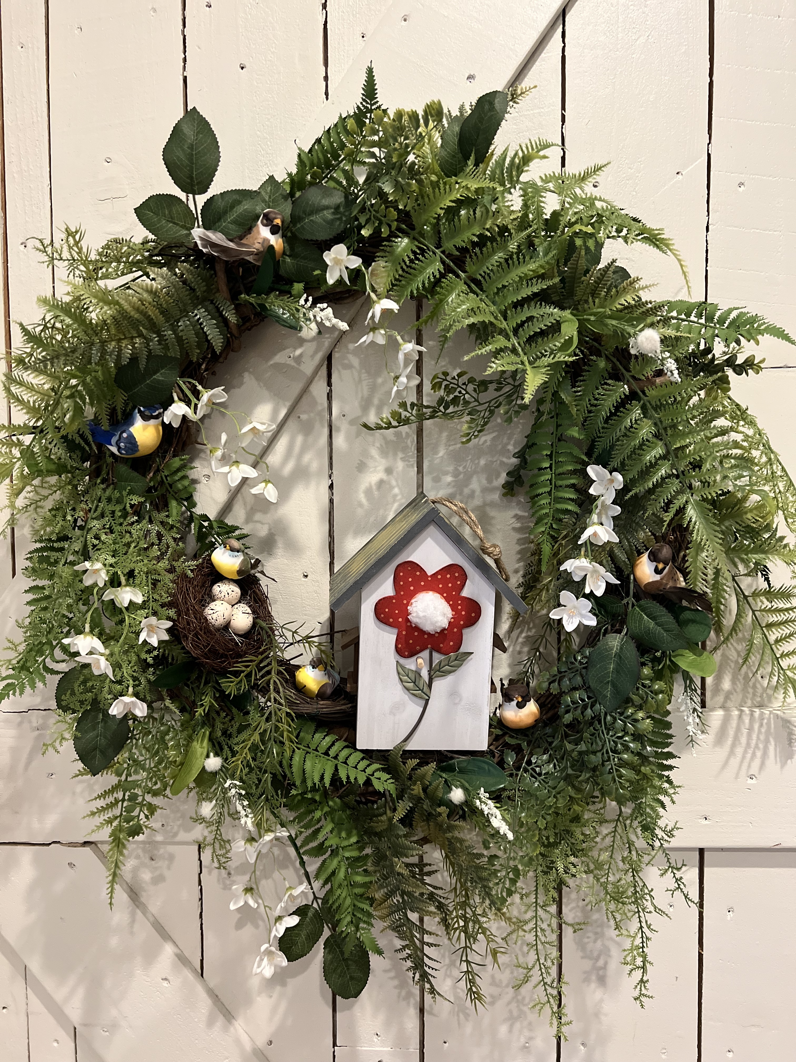 Handmade spring wreath with birdhouse and ferns
